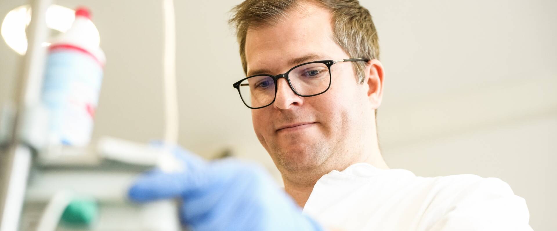 Arzt mit Brille bereitet Infusion vor